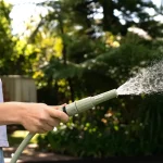 Holman ColourDip™ Green 12mm x 15m garden hose with adjustable nozzle, perfect for versatile garden watering